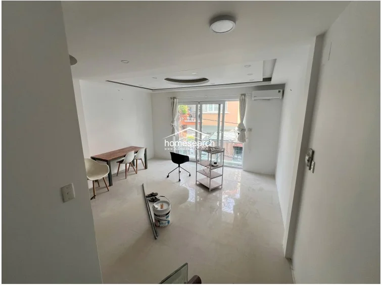 This elevated view from the stairs captures the overall flow of the main living floor, showcasing the airy, uncluttered design. The room is currently sparsely furnished, emphasizing the versatility of the floor plan and the bright, reflective quality of the polished tile floors.