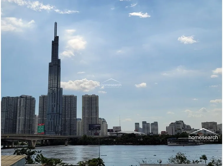 This image captures a stunning, unobstructed view of the city's iconic skyscraper and the riverfront, highlighting the property's prime location. The expansive sky and urban landscape suggest a high-floor vantage point that maximizes natural light and provides a dramatic backdrop for the residence.