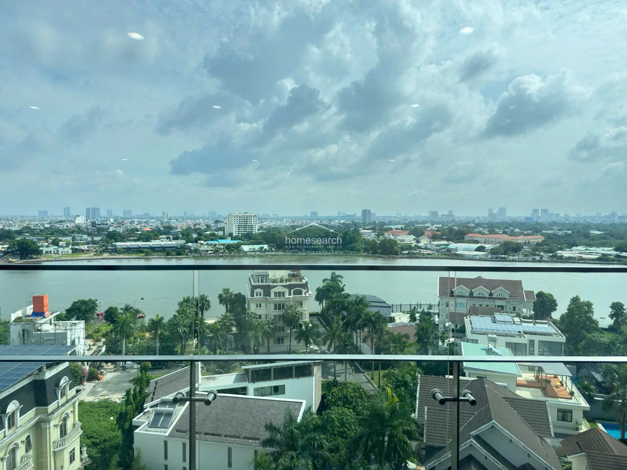 The balcony offers a stunning, unobstructed panoramic view of the river and the surrounding urban landscape. It features a modern glass railing, ensuring safety without compromising the visual connection to the outdoors. This outdoor space serves as a serene extension of the living area, perfect for enjoying the scenery.