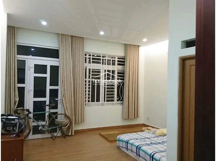 This bedroom perspective shows the transition between the sleeping area and the balcony, emphasizing the room's open and airy feel. The space is finished with light-colored walls, wood-look flooring, and recessed ceiling lighting, presenting a clean and functional living environment.