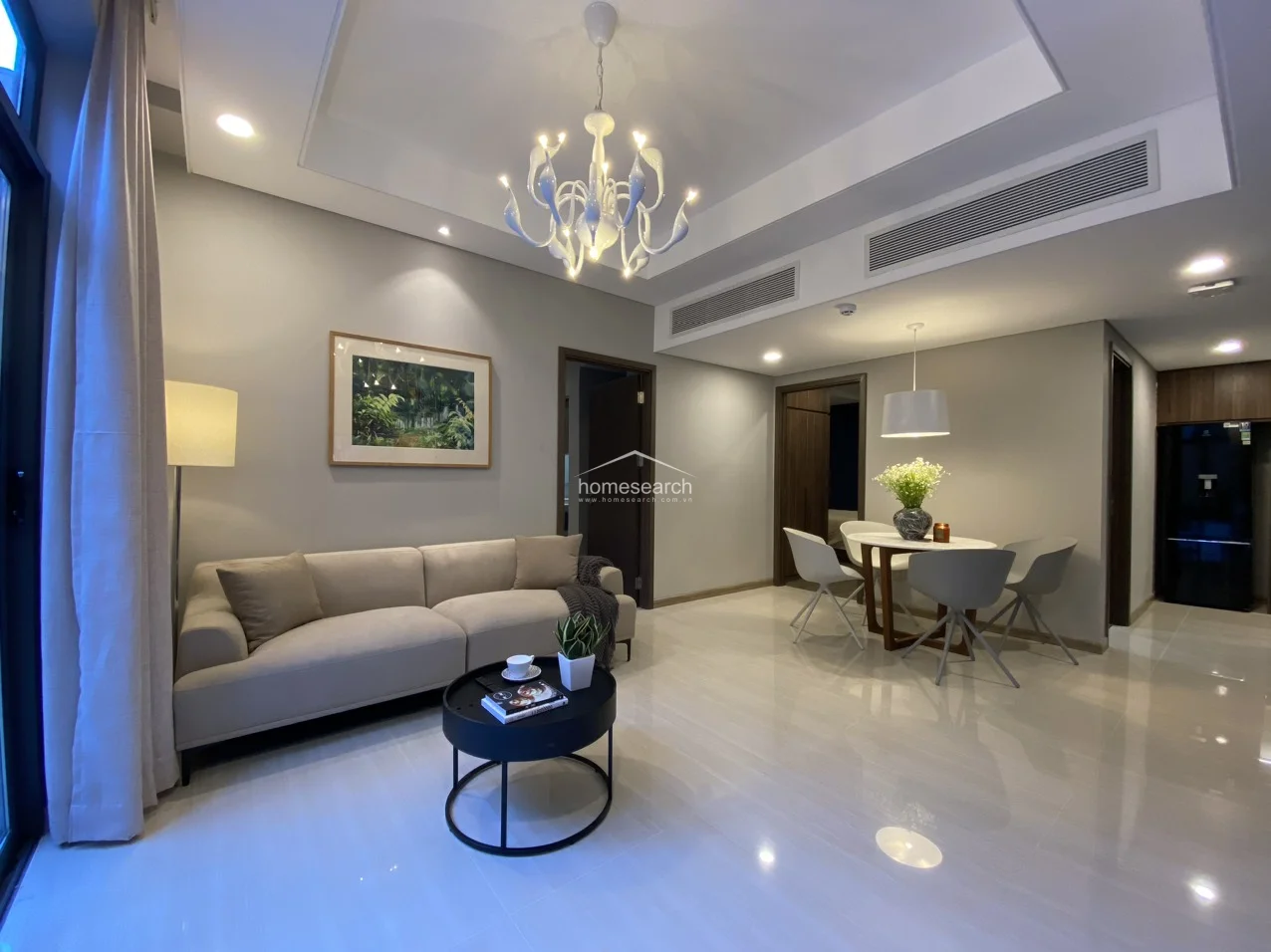 This wide-angle shot showcases the cohesive design of the entire living and dining space, emphasizing the high tray ceilings and integrated central air conditioning system. The property is in excellent condition, featuring a balanced mix of modern fixtures, natural textures, and a thoughtful, airy flow.