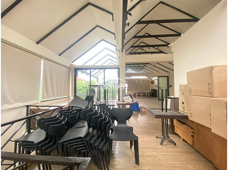 This section of the floor plan emphasizes the open-concept design, with large windows and a glass-paneled ceiling that floods the space with natural light. The room is currently used for storage, but the architectural details, such as the exposed beams and neutral color palette, provide a versatile canvas for various uses.