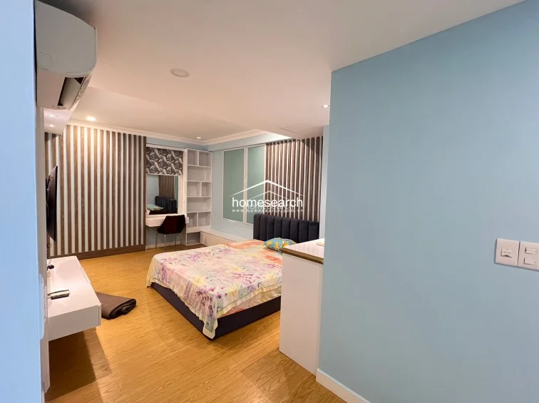 This angle of the bedroom showcases the integrated storage solutions, including a built-in vanity with shelving and floor-to-ceiling wardrobe cabinets that maximize vertical space. The room is accented by vertical wood slat wall detailing, which adds texture and warmth to the modern, minimalist aesthetic.