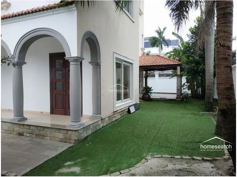 This interior perspective looks out through large sliding glass doors, offering a direct view of the garden and greenery outside. The room is finished with neutral-toned walls and white curtains, creating a bright and airy atmosphere that connects the indoor living space to the outdoors.