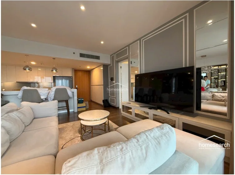 This open-concept living area features rich wood flooring and elegant grey walls accented with white molding and mirror panels. The space is flooded with natural light from floor-to-ceiling windows that offer expansive views and provide access to a balcony.