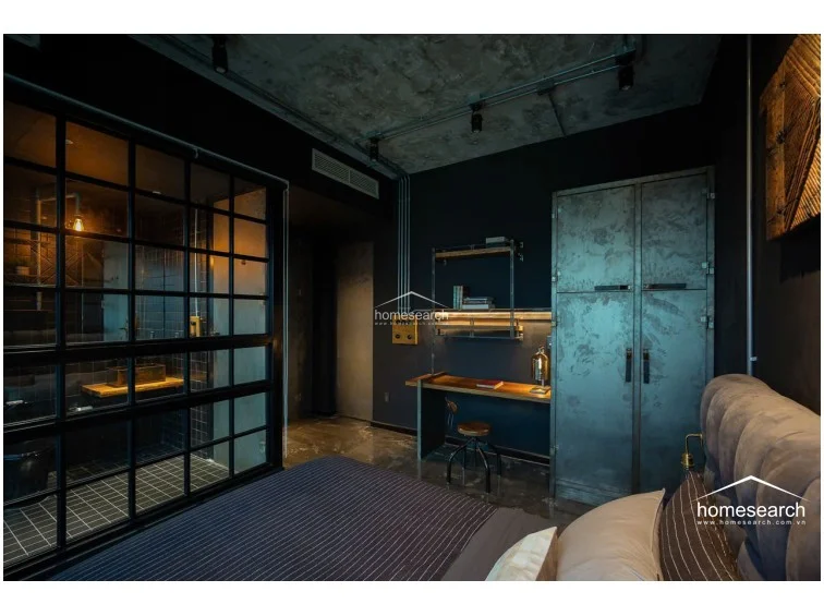 This view highlights the bedroom's cohesive industrial aesthetic, emphasizing the sleek, dark walls and the seamless transition toward the windowed corner. The minimalist furniture, including a metal wardrobe and matching nightstands, maintains a clean, uncluttered flow that draws the eye toward the impressive exterior view.