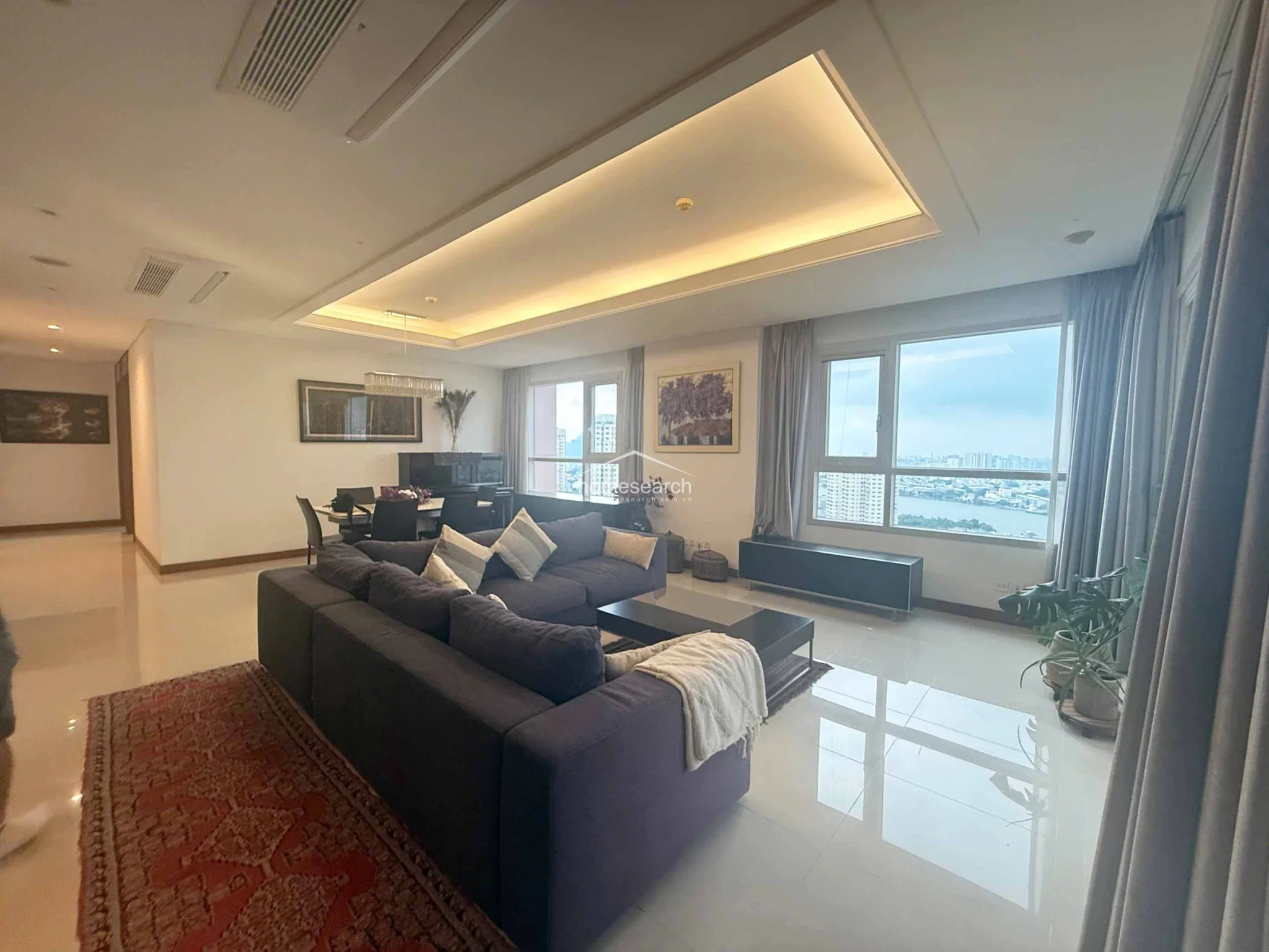 This perspective captures the depth of the living room, highlighting the integration of the balcony space and the natural light flooding the interior. The property appears to be in excellent condition, featuring high-quality fixtures and a thoughtful architectural design that maximizes both space and the scenic exterior views.