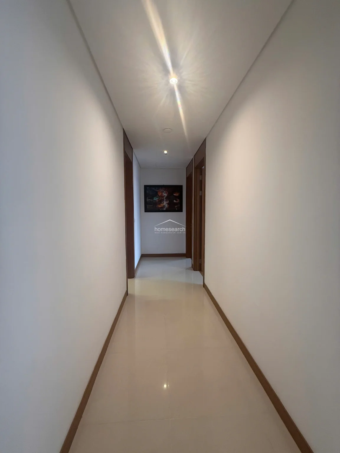 This hallway is identical to the previous view, reinforcing the consistent, neutral aesthetic and high-maintenance finish of the property's interior. The long, narrow layout provides a seamless flow, connecting various living areas while maintaining a bright and airy atmosphere.