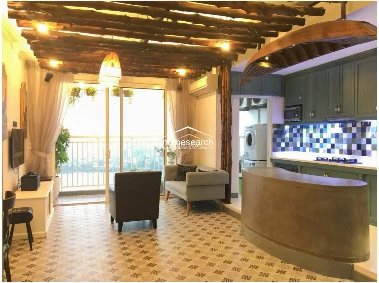 This open-concept living and kitchen area features a unique rustic ceiling design with exposed wooden branches and integrated lighting. The space flows seamlessly to a balcony through large glass sliding doors, which provide ample natural light and expansive outdoor views.