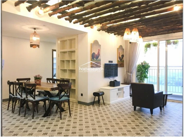The dining area is anchored by a substantial live-edge wooden table and matching chairs, set against a backdrop of patterned tile flooring. A built-in floor-to-ceiling shelving unit provides excellent storage, while a decorative birdcage pendant light adds a whimsical, rustic touch to the space.