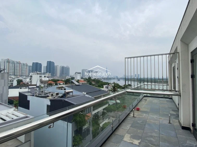 This expansive terrace offers an open-air experience with panoramic city and river views, secured by modern glass and metal railings. The space is paved with durable stone tiles and provides a generous outdoor area, perfect for entertaining or relaxing in an urban setting.