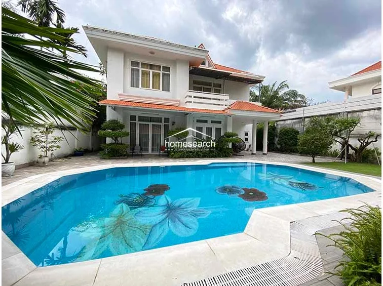 This image provides an alternate view of the villa’s exterior, highlighting the seamless indoor-outdoor flow provided by large glass sliding doors that open directly onto the pool deck. The property appears to be in excellent condition, with well-maintained landscaping and a clean, inviting pool area that serves as the focal point of the backyard.