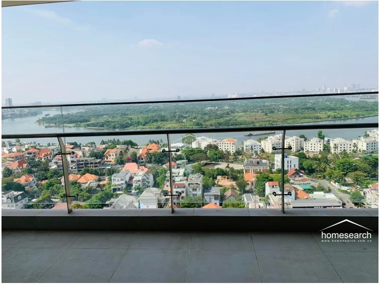 This spacious balcony features modern glass railings and large-format floor tiles, providing an unobstructed, elevated view of the river and surrounding residential area. It serves as an ideal outdoor extension of the living space, perfect for enjoying the scenery and fresh air.