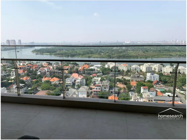 The balcony is finished with neutral-toned floor tiles and features a sleek, frameless glass railing that ensures an unobstructed view of the river and surrounding cityscape. This outdoor space is well-maintained and provides a perfect vantage point for enjoying the elevated, scenic location.