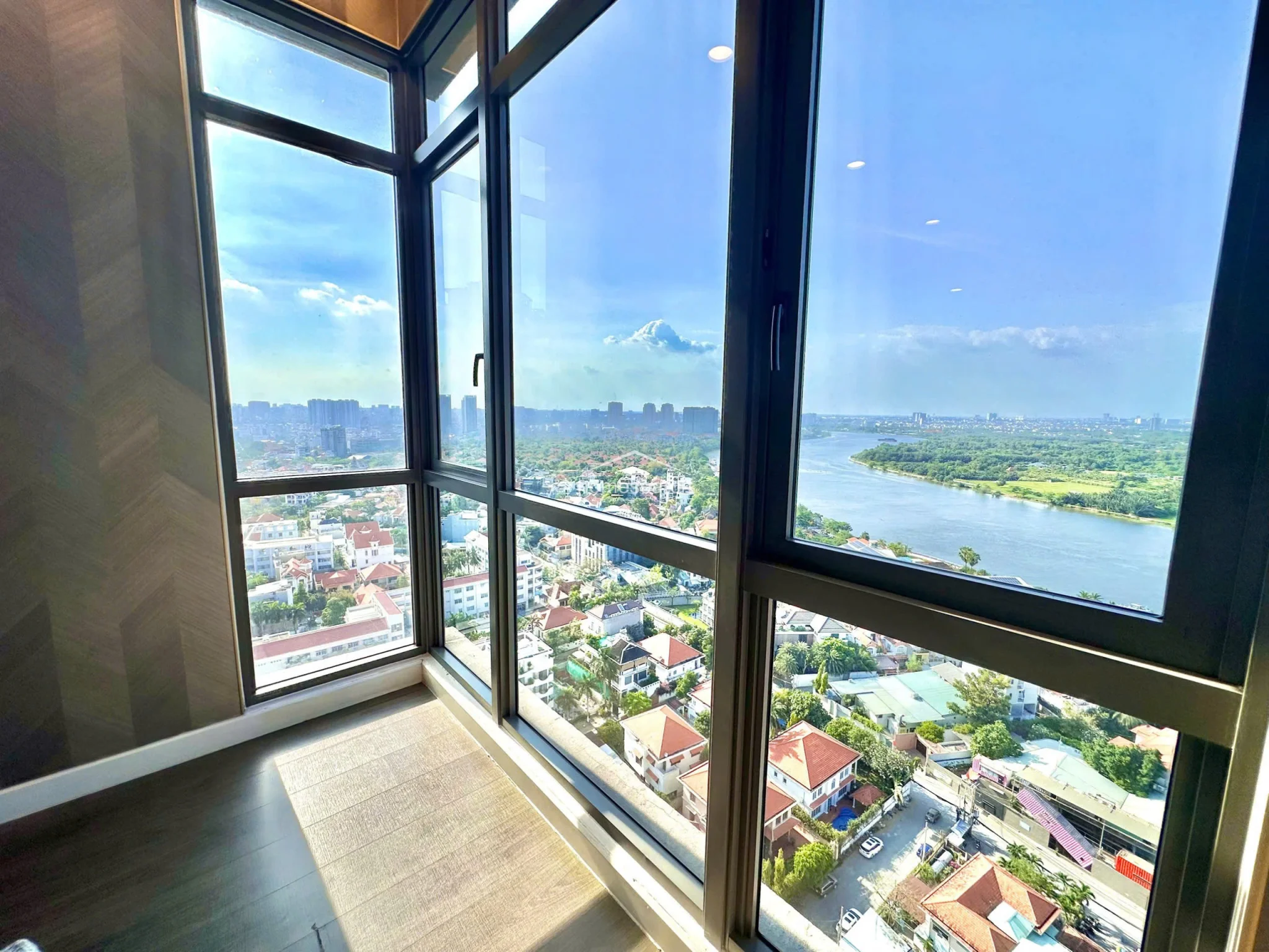 The bedroom’s standout feature is the corner floor-to-ceiling window system, which offers breathtaking, unobstructed views of the river and surrounding cityscape. The design prioritizes natural light and architectural simplicity, providing a serene environment that feels connected to the outdoors.
