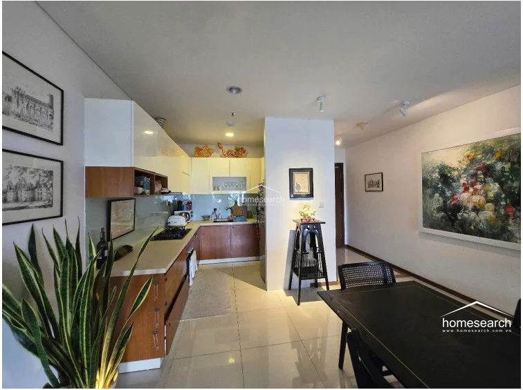 This wide-angle shot captures the entire living and dining zone, showcasing the balanced layout and the effective use of lighting to define different functional areas. The apartment maintains a high standard of condition, with consistent flooring and a neutral color palette that provides a versatile backdrop for the sophisticated furniture and decor.