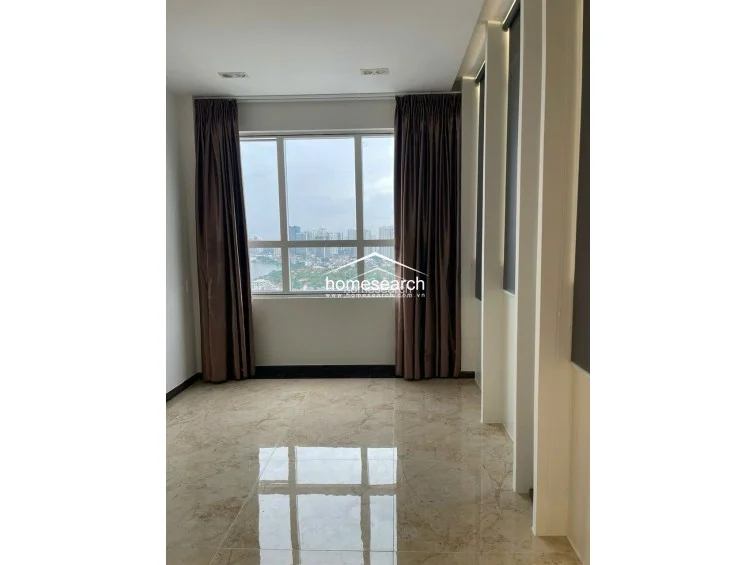 This view highlights the bedroom's architectural details, including vertical wall paneling and recessed lighting, which add depth to the room. The large window provides a panoramic city outlook, while the marble flooring and clean lines reflect a modern, well-maintained interior.