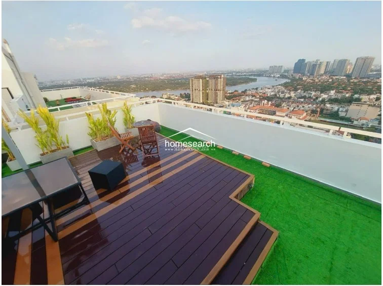 This angle of the terrace highlights the tiered wooden decking, which creates a distinct separation from the artificial grass area. It is an open, airy space that maximizes the impressive skyline views and appears to be in excellent condition.