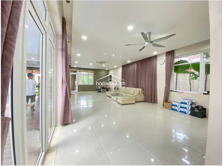 This functional kitchen layout features a U-shaped design with a breakfast bar extension, maximizing counter space and flow. It is equipped with high-contrast black lower cabinets and white upper cabinets, providing ample storage, and includes a large Sharp refrigerator and integrated appliances. The space is well-lit with recessed lighting and features a glass door that opens to an outdoor area, enhancing ventilation and natural light.